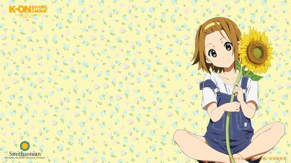 Anime picture 1920x1080 with k-on! kyoto animation tainaka ritsu single looking at viewer highres short hair smile brown hair wide image sitting brown eyes girl flower (flowers) hairband sunflower overalls