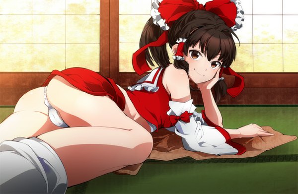 Anime picture 1150x750 with touhou hakurei reimu parabora (nipplemokuba) single long hair looking at viewer blush light erotic smile brown hair ass ponytail lying from behind on stomach chin rest upskirt butt crack naughty face girl
