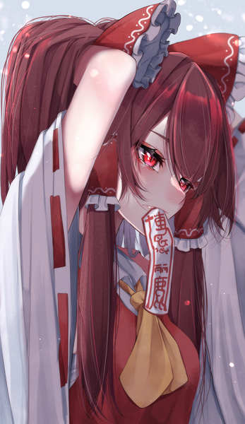 Anime picture 1447x2500 with touhou hakurei reimu tsune (tune) single long hair tall image blush fringe hair between eyes red eyes brown hair looking away upper body traditional clothes japanese clothes wide sleeves arms up mouth hold adjusting hair girl