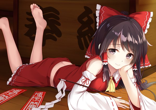 Anime picture 1500x1061 with touhou hakurei reimu flan (seeyouflan) single long hair looking at viewer blush black hair smile holding brown eyes lying traditional clothes japanese clothes wide sleeves arm support on stomach miko leg lift (legs lift) girl